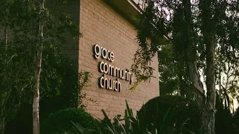 Grace Community Church exterior sign on a brick wall surrounded by greenery