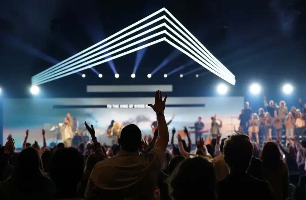 Congregation with hands raised during worship in the McLean Bible Church auditorium