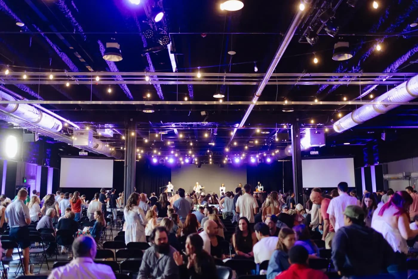 Interior worship space at Church of the City with congregation gathered and band on stage