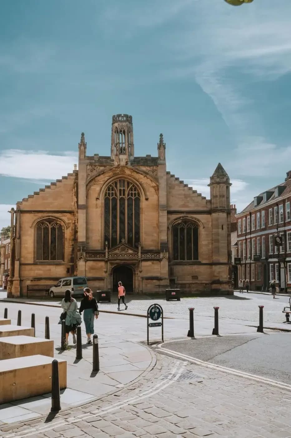 Exterior of St Michael le Belfrey church in York, a Gothic stone building on a cobbled street